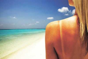 Mujer en la playa con marcas del sol del bikini